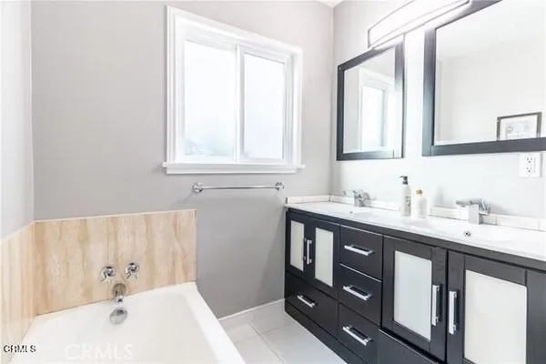 a bathroom with a tub sink and mirror