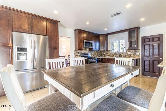 412 South Kenneth Road Burbank, CA 91501 - Photo 7 of 24 a kitchen with stainless steel appliances granite countertop a refrigerator a stove and a sink with wooden floor