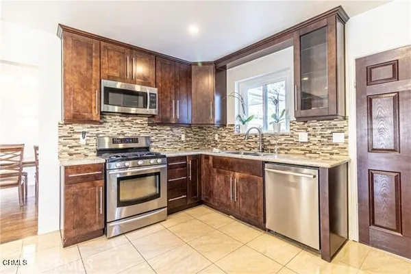 a kitchen with stainless steel appliances granite countertop a stove sink microwave and cabinets