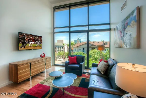a living room with furniture cabinets and a large window