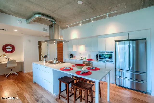 a room with a table chairs and kitchen view
