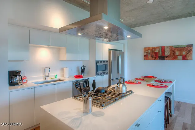a kitchen with a sink a stove and chairs
