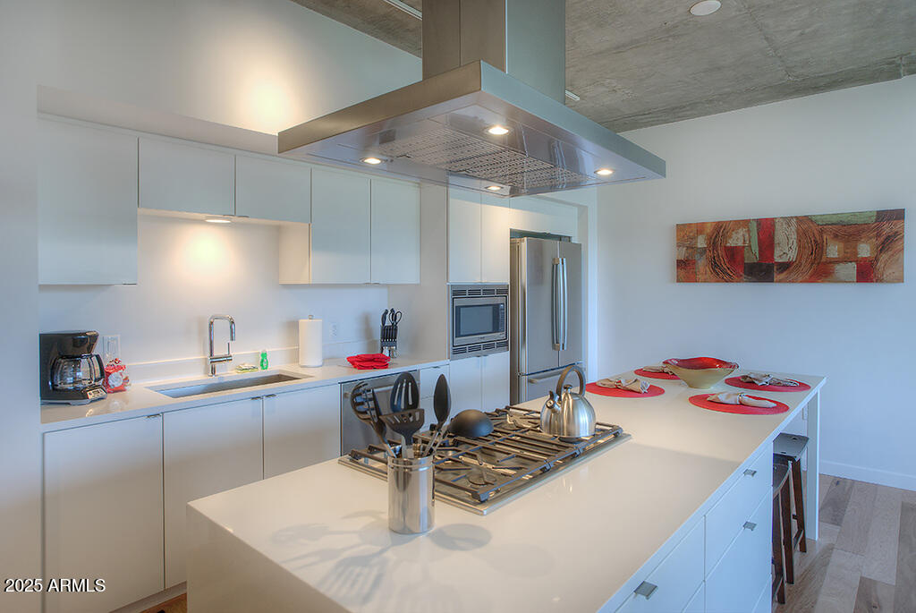 100 West Portland Street, Unit 506 Phoenix, AZ 85003 - Photo 6 of 25 a kitchen with a sink a stove and chairs