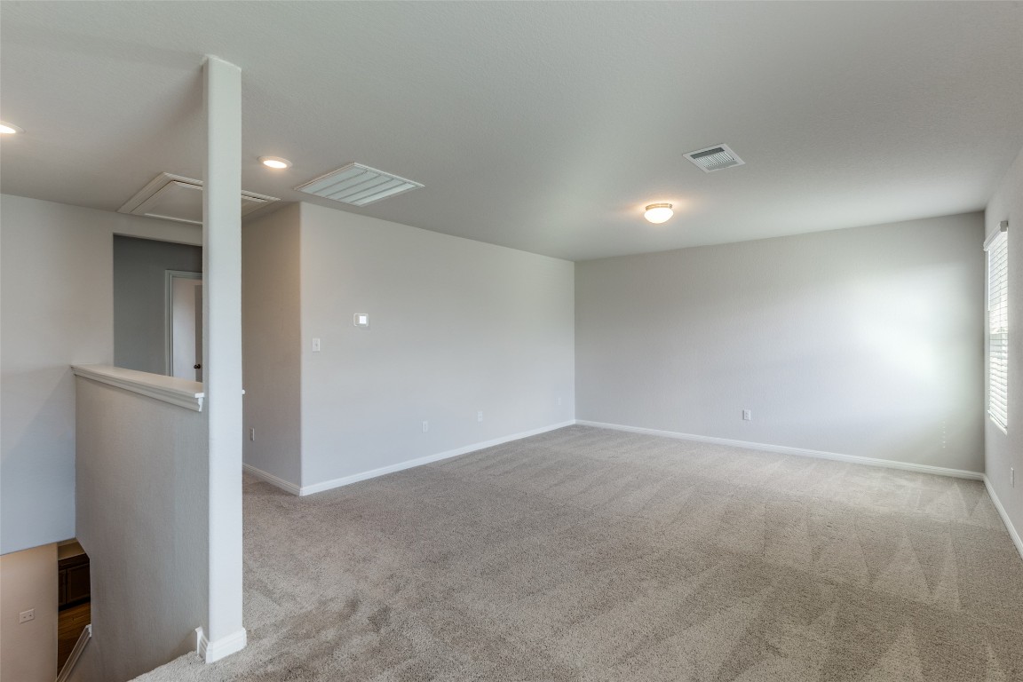 12912 Cerro Castellan Trace Manor, TX 78653 - Photo 12 of 36 an empty room with windows and entrance to other room