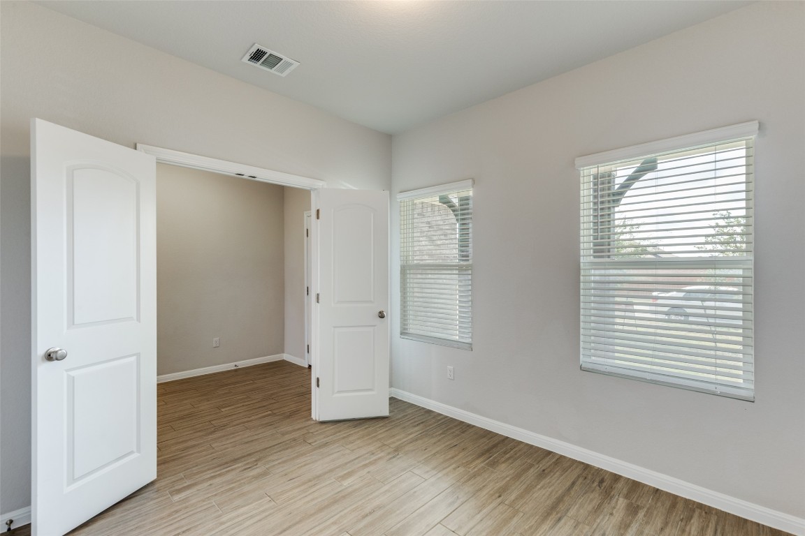 12912 Cerro Castellan Trace Manor, TX 78653 - Photo 16 of 36 an empty room with wooden floor and windows