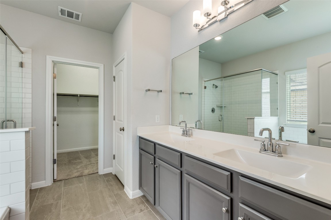 12912 Cerro Castellan Trace Manor, TX 78653 - Photo 19 of 36 a bathroom with a sink and a mirror