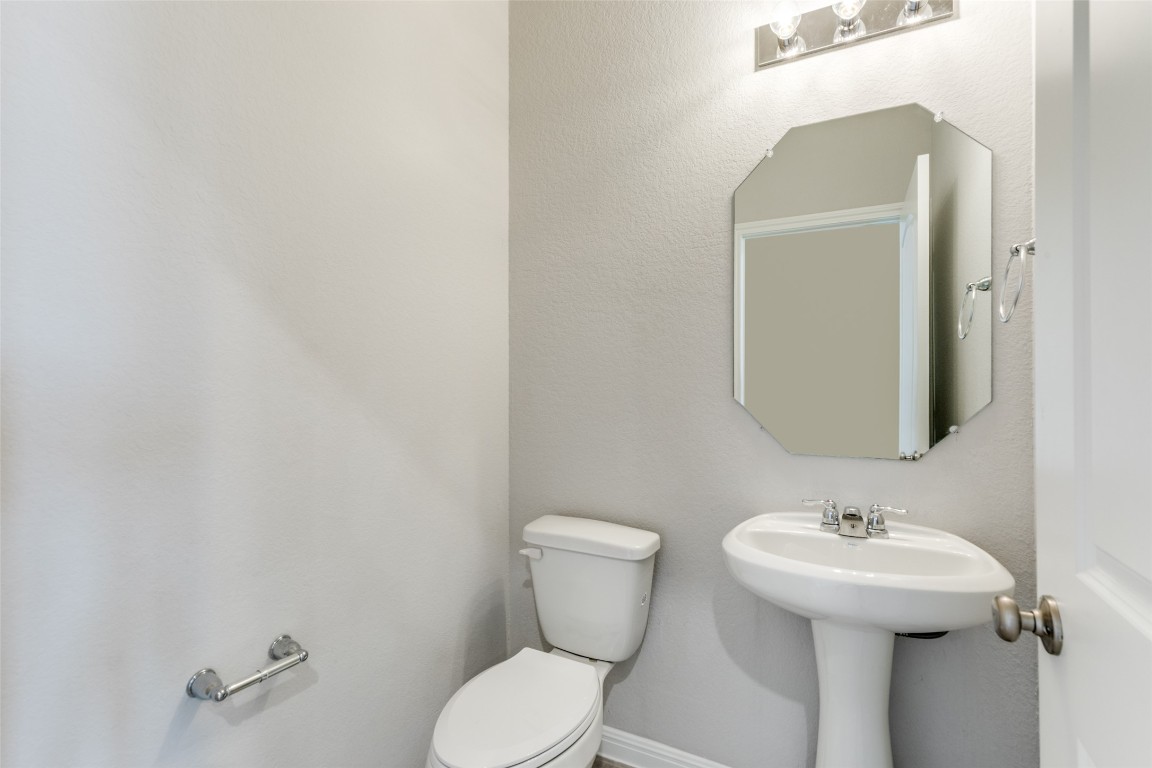12912 Cerro Castellan Trace Manor, TX 78653 - Photo 28 of 36 a bathroom with a toilet sink and mirror