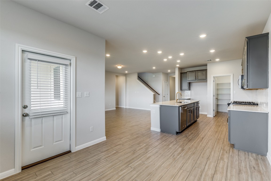 12912 Cerro Castellan Trace Manor, TX 78653 - Photo 30 of 36 a view of kitchen with kitchen island wooden floor center island and stainless steel appliances