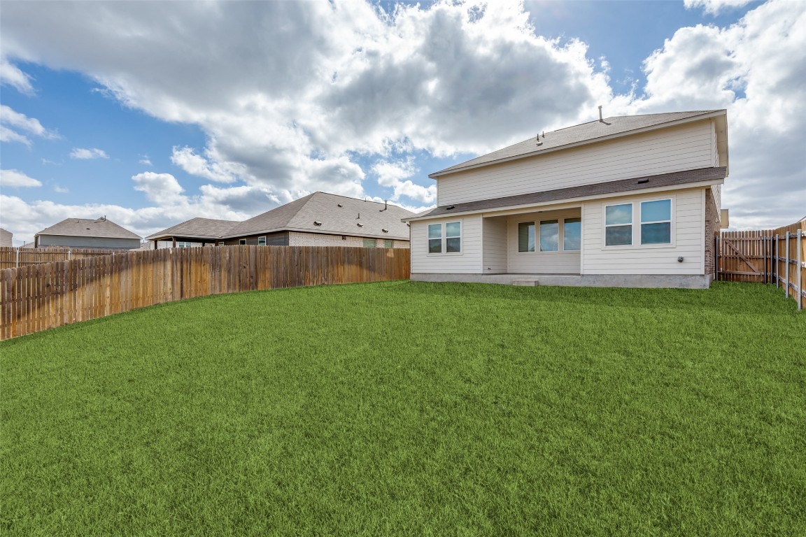 12912 Cerro Castellan Trace Manor, TX 78653 - Photo 33 of 36 a view of a house with a big yard and large tree