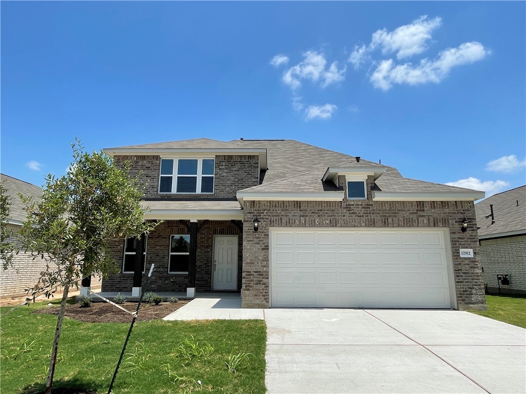 12912 Cerro Castellan Trace Manor, TX 78653 - Photo 35 of 36 a front view of a house with a yard and a garage