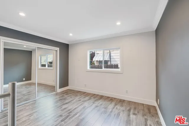 a view of empty room with wooden floor and windows