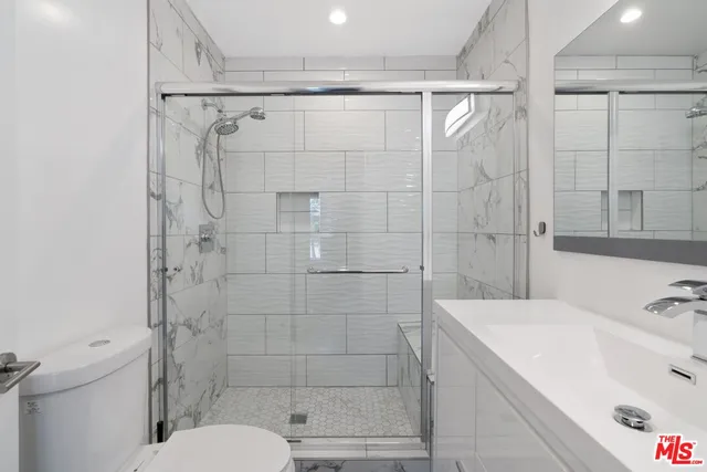 a bathroom with a shower sink and mirror