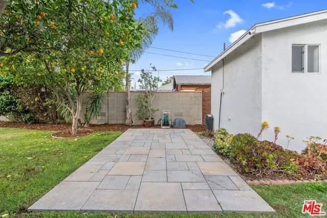 a view of a patio with couches table and chairs and potted plants