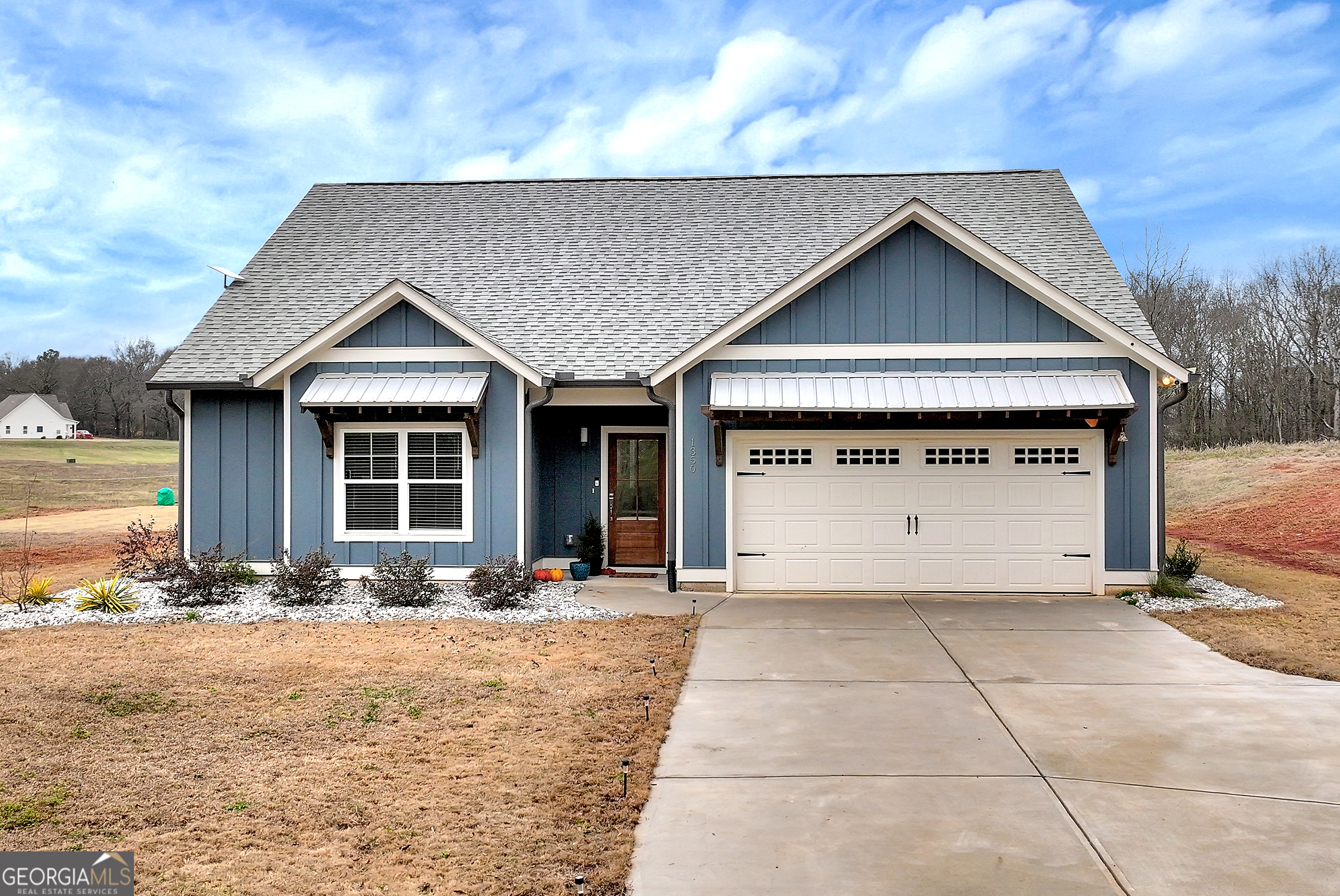 a view of a house with wooden fence next to a yard