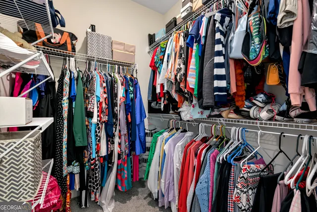 a view of walk in closet with clothes
