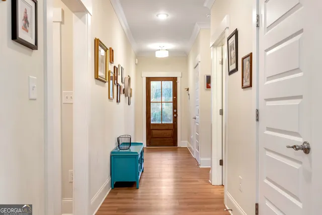a view of a hallway with wooden floor and stairs