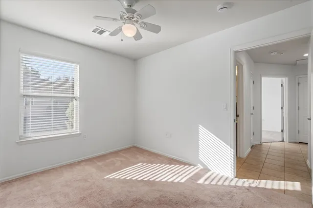 a view of a room with wooden floor and fan
