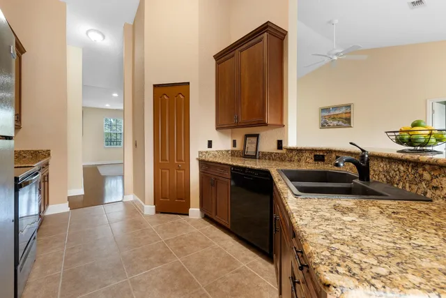 a kitchen with stainless steel appliances granite countertop a stove a sink and a refrigerator