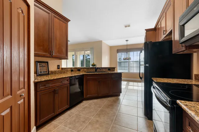 a kitchen with stainless steel appliances granite countertop a refrigerator and a stove top oven