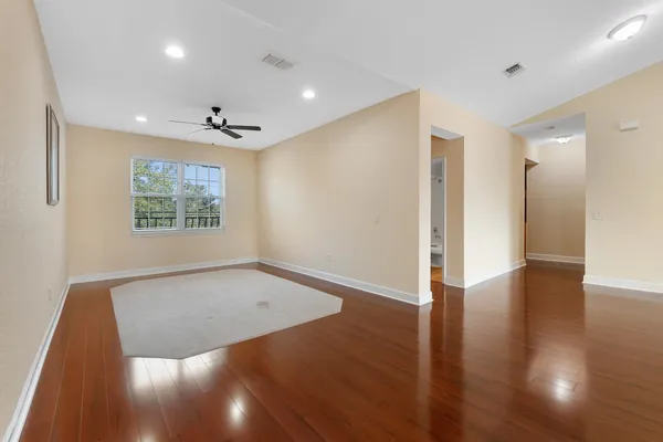 an empty room with wooden floor and windows