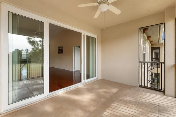 a view of a big room with windows and chandelier fan