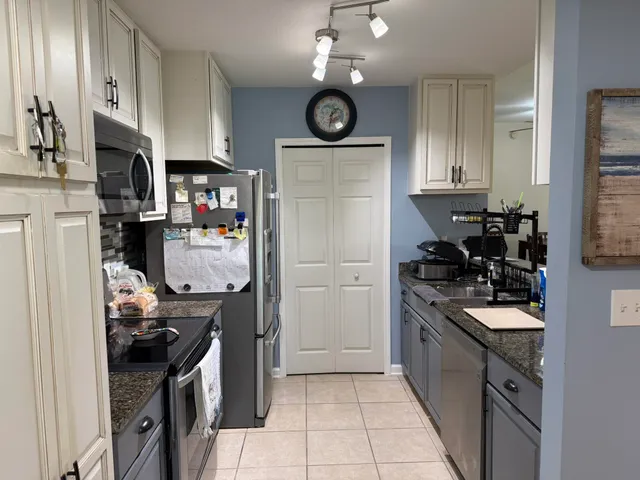 a kitchen with stainless steel appliances granite countertop a stove top oven a sink a counter space and cabinets