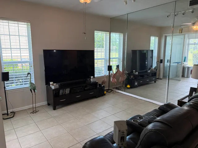 a living room with furniture a flat screen tv and a window