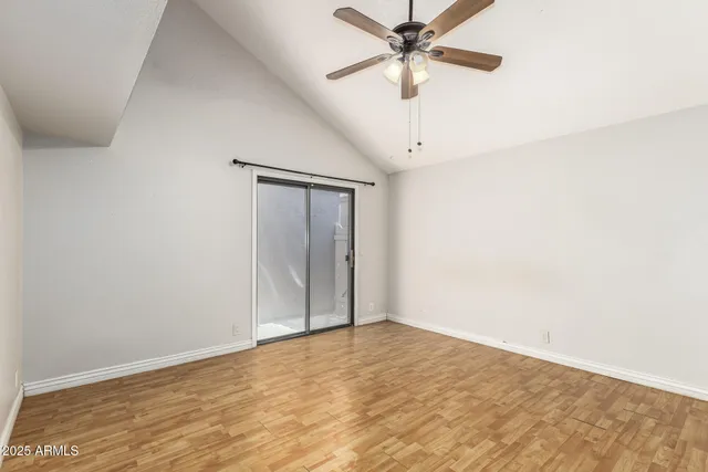 an empty room with fan and windows