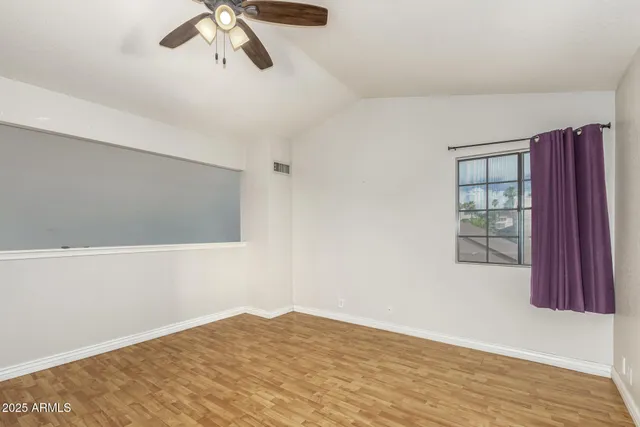 a view of a livingroom with wooden floor and a ceiling fan