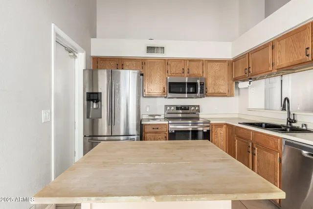 a kitchen with stainless steel appliances granite countertop a refrigerator stove microwave and sink