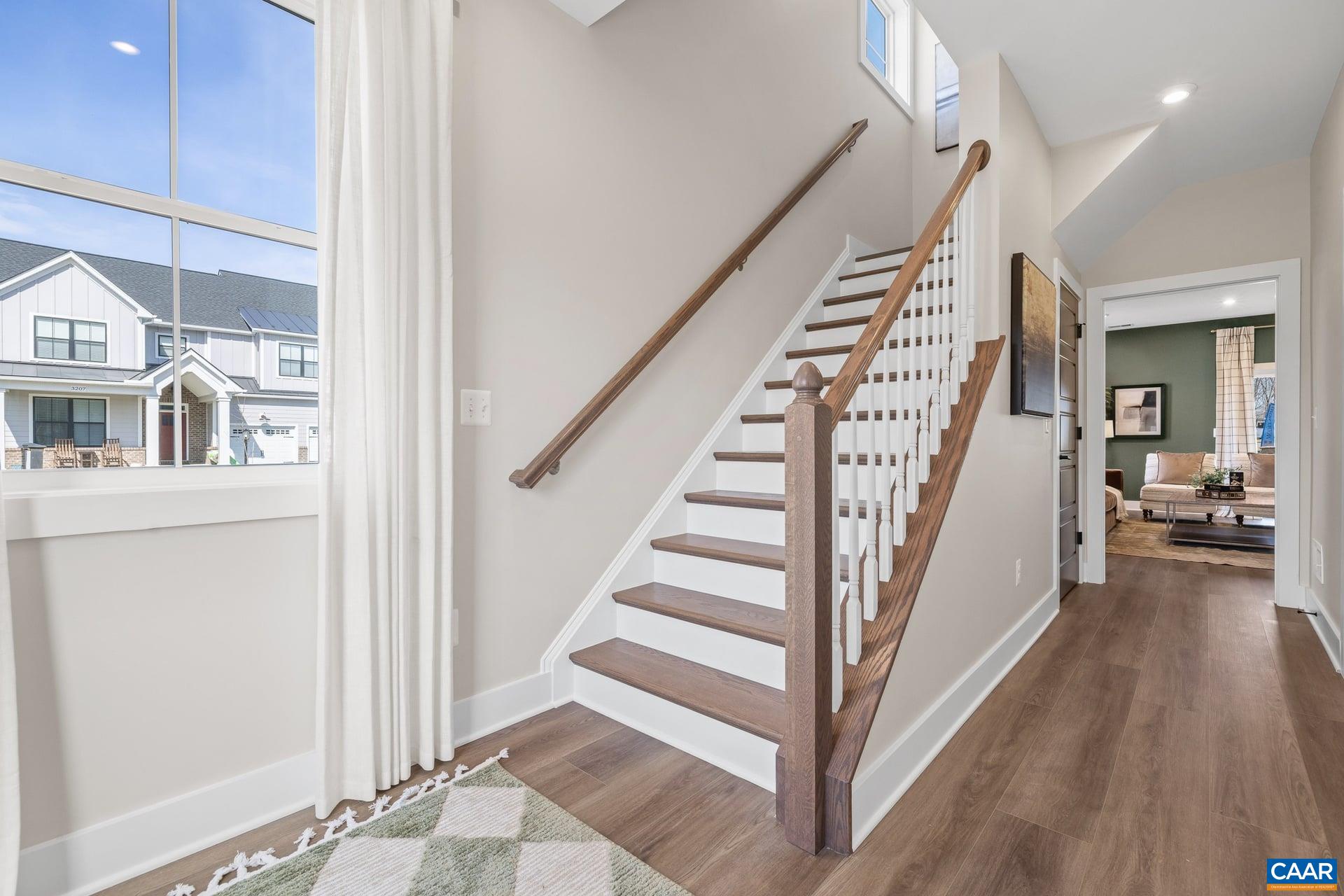 48 B Miranda Crossing Charlottesville, VA 22901 - Photo 6 of 28 a view of a hallway to a livingroom with wooden floor and stairs