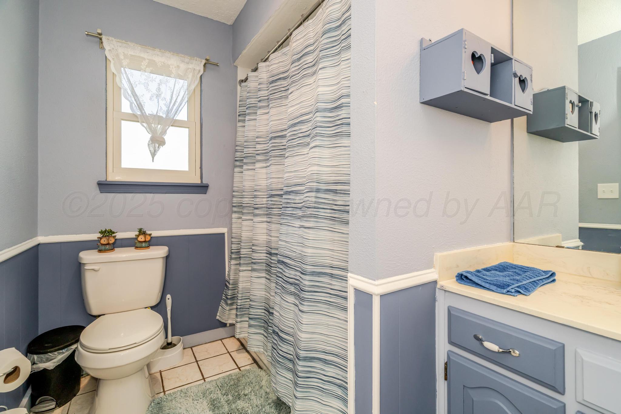 7909 Gerald Drive Amarillo, TX 79121 - Photo 11 of 26 a bathroom with a toilet and a sink