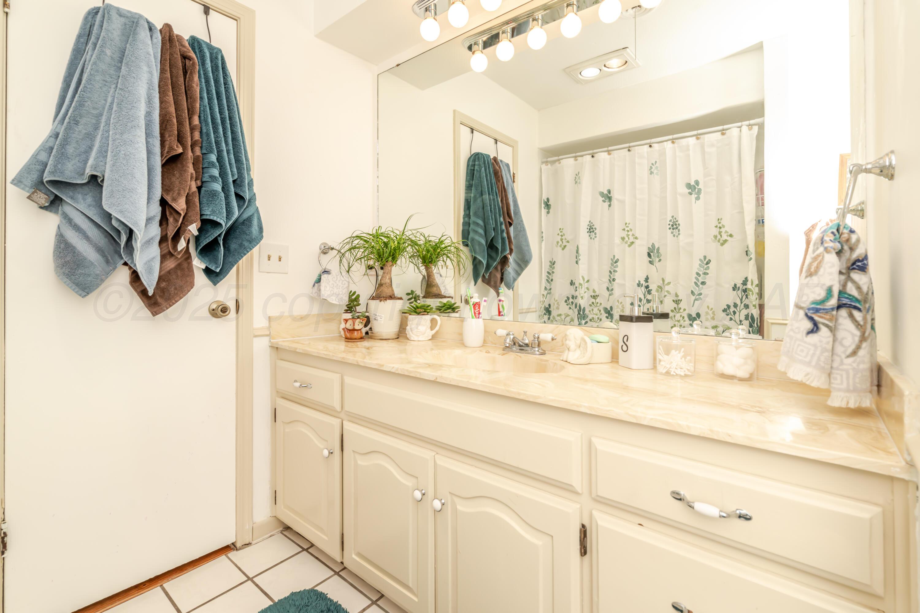 7909 Gerald Drive Amarillo, TX 79121 - Photo 12 of 26 a bathroom with a sink and a mirror