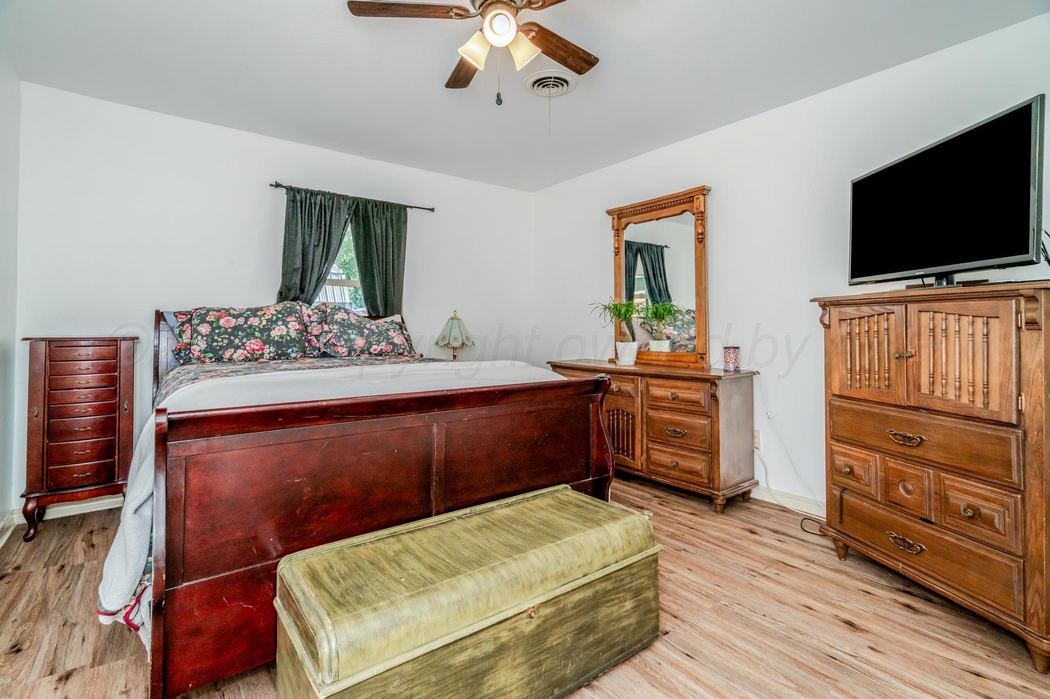 7909 Gerald Drive Amarillo, TX 79121 - Photo 13 of 26 a bedroom with a bed and flat tv screen on the dresser