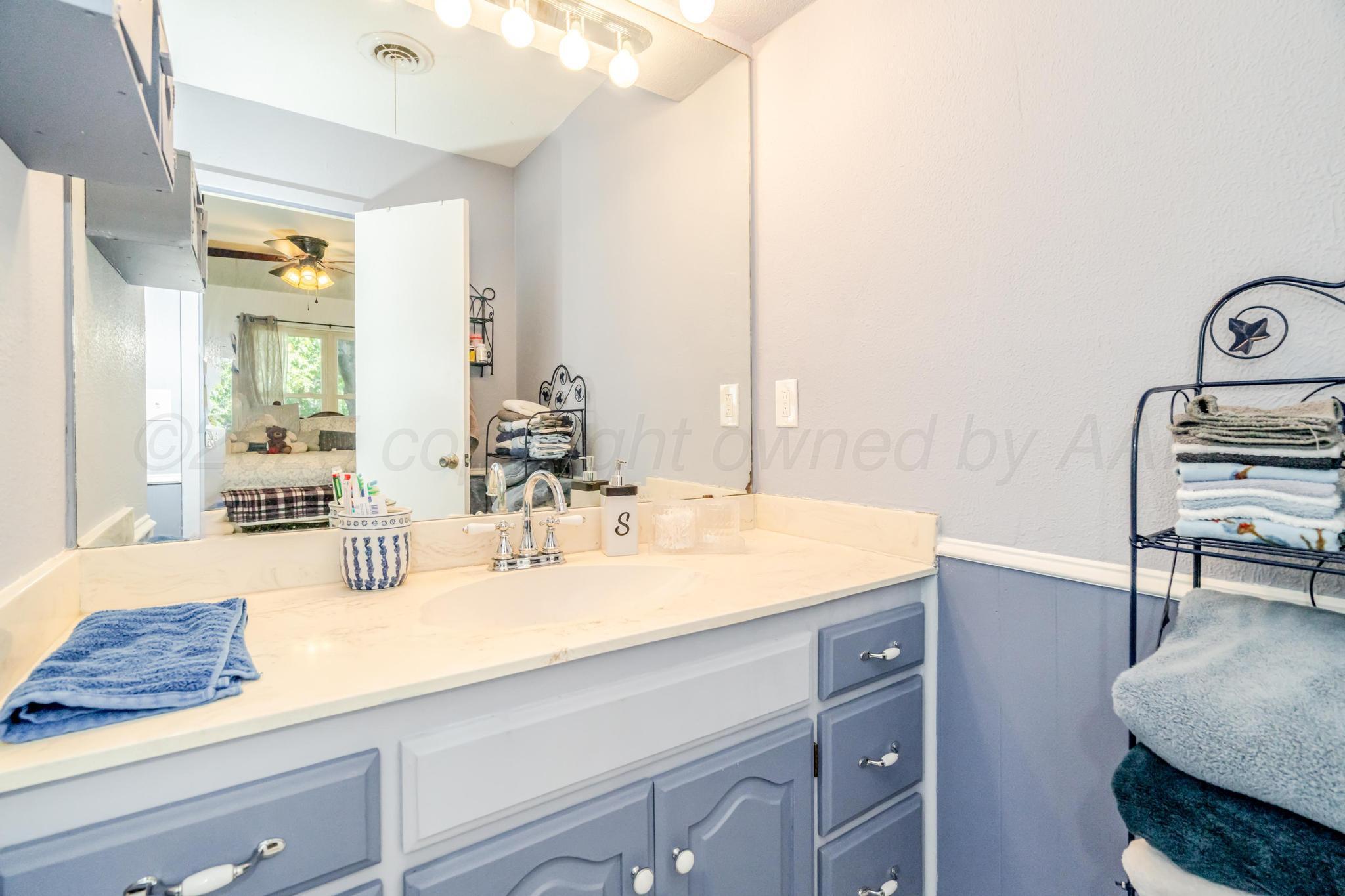 7909 Gerald Drive Amarillo, TX 79121 - Photo 9 of 26 a bathroom with a sink and a mirror