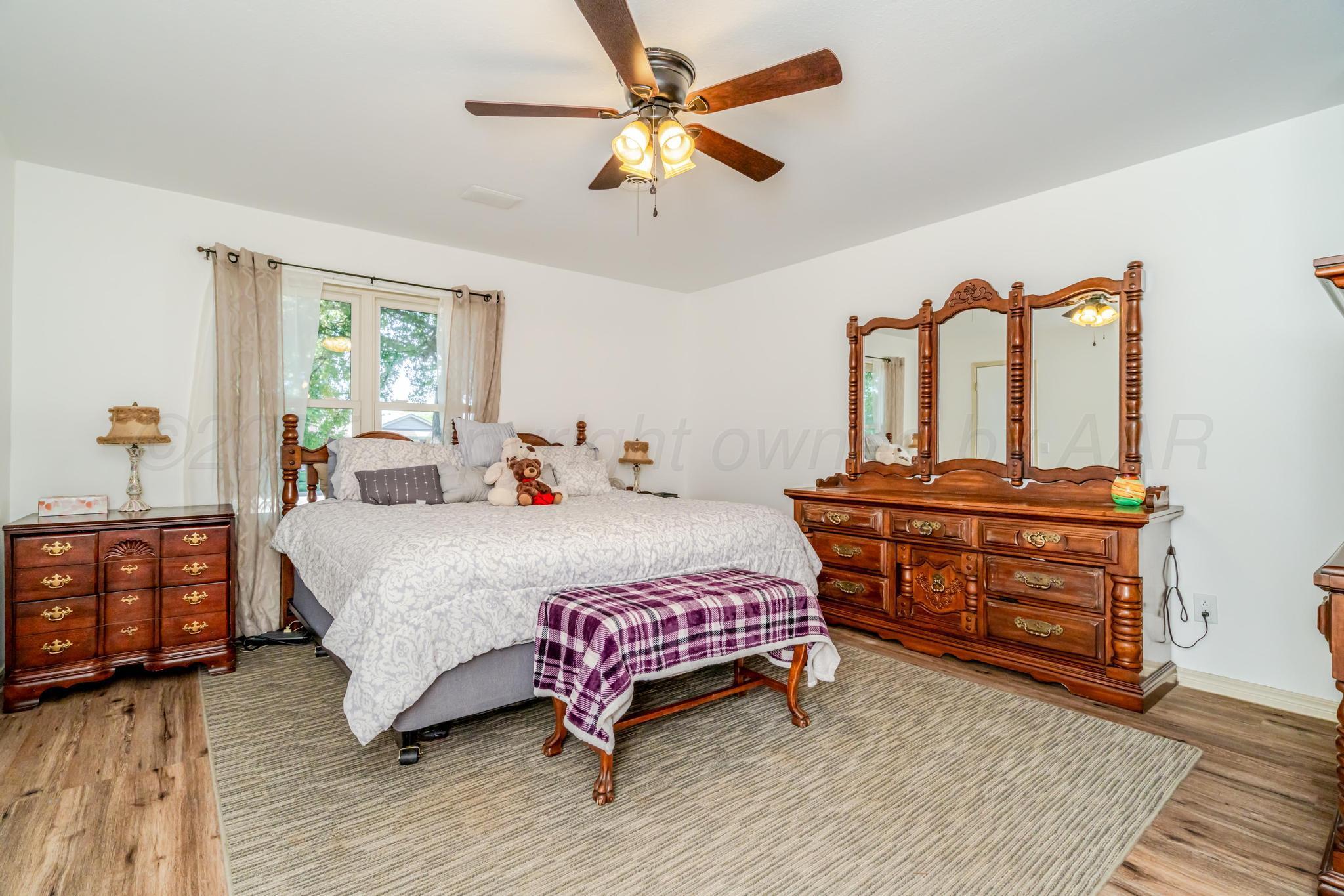 7909 Gerald Drive Amarillo, TX 79121 - Photo 10 of 26 a bedroom with a bed and wooden floor
