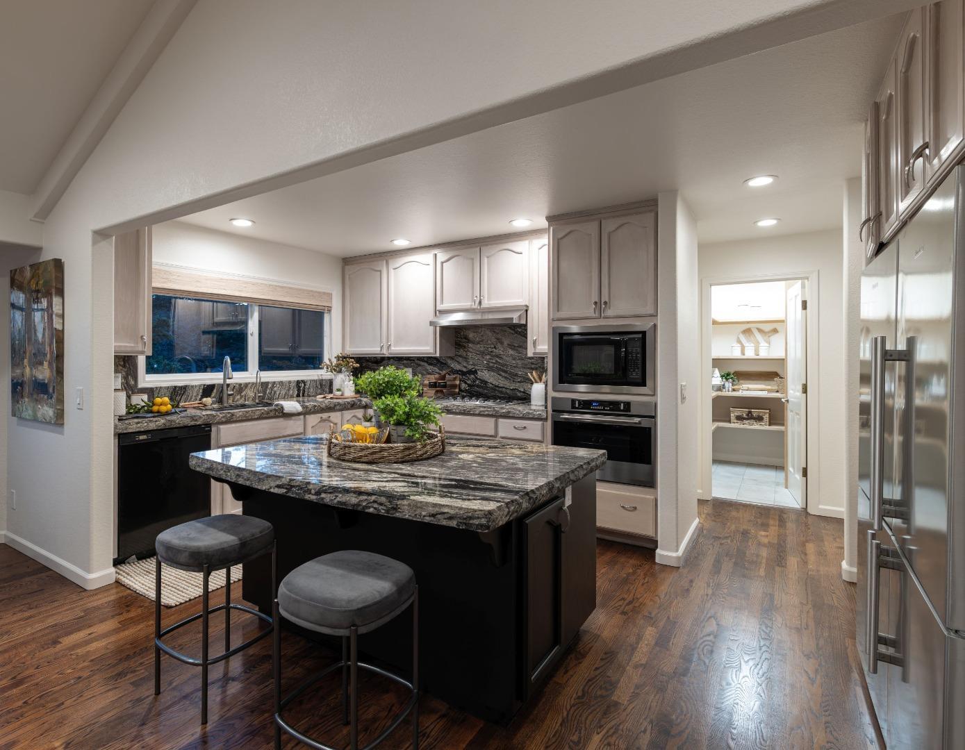 573 Meadow Road Aptos, CA 95003 - Photo 18 of 53 a kitchen with kitchen island granite countertop wooden floors and wooden cabinets