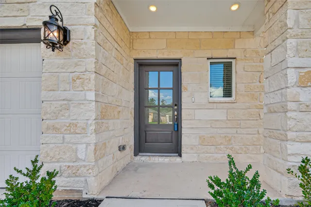 a view of a hallway to a livingroom with wooden floor and staircase
