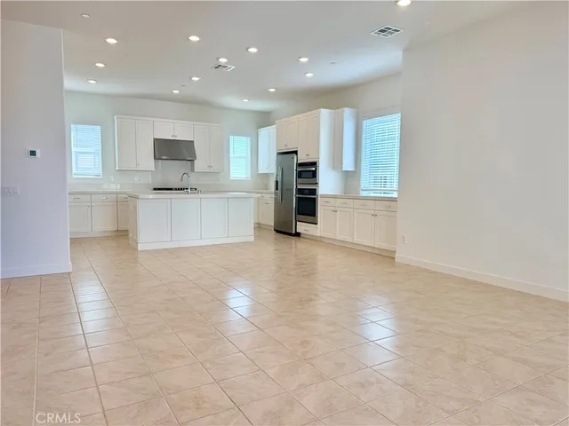 a large kitchen with stainless steel appliances a refrigerator and a stove top oven