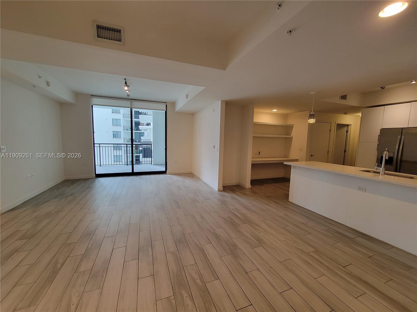 999 Southwest 1st Avenue, Unit 2016 Miami, FL 33130 - Photo 16 of 49 an empty room with wooden floor and windows