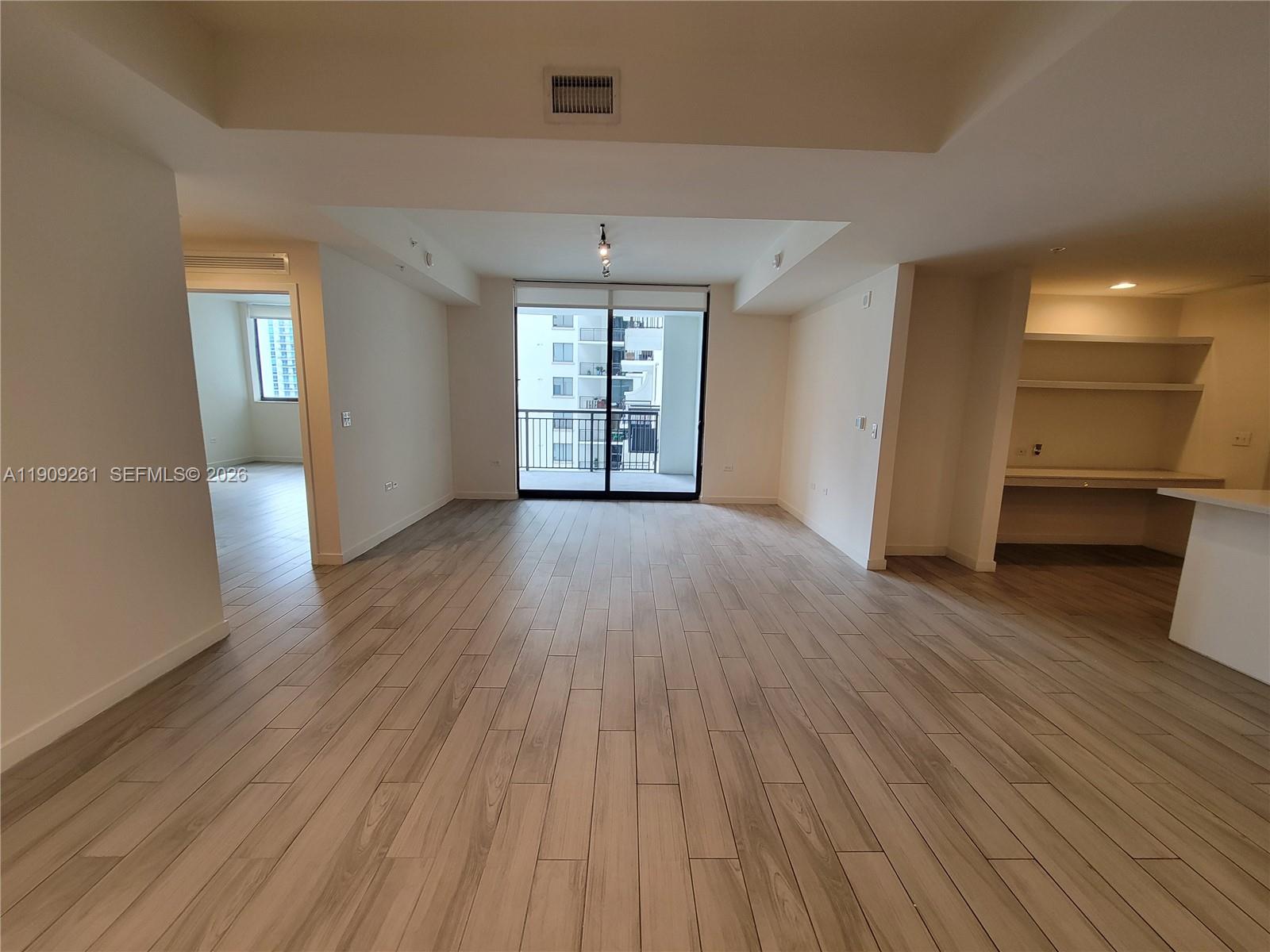 999 Southwest 1st Avenue, Unit 2016 Miami, FL 33130 - Photo 19 of 49 wooden floor in an empty room with a window