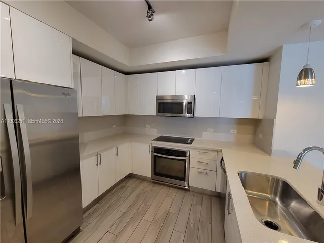a kitchen with stainless steel appliances a refrigerator and a stove top oven