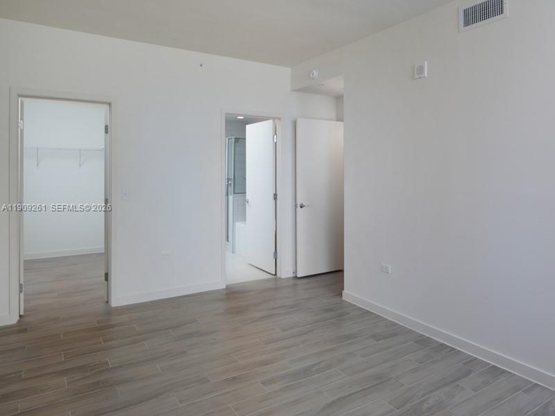 999 Southwest 1st Avenue, Unit 2016 Miami, FL 33130 - Photo 24 of 49 a view of an empty room with wooden floor