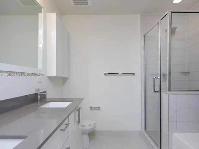 a bathroom with a sink a toilet a shower and a mirror