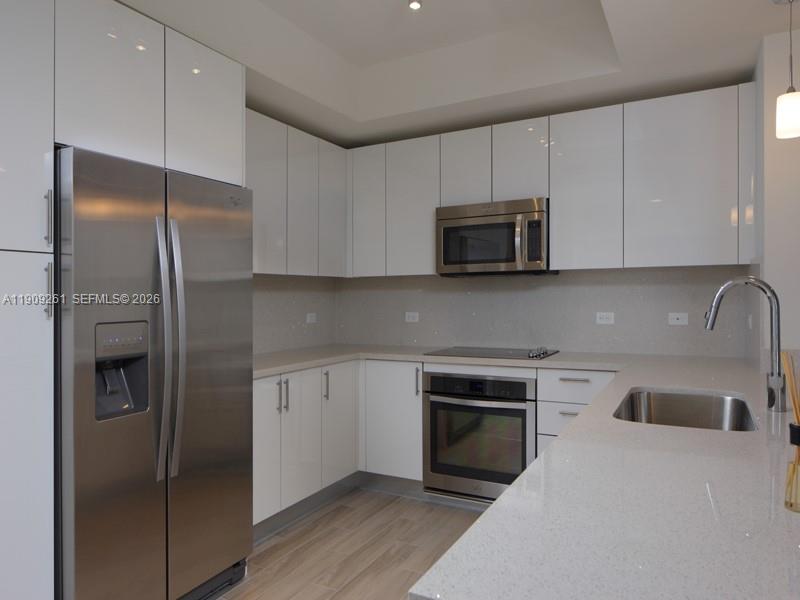 999 Southwest 1st Avenue, Unit 2016 Miami, FL 33130 - Photo 4 of 49 a kitchen with stainless steel appliances granite countertop a refrigerator a stove a sink and a microwave