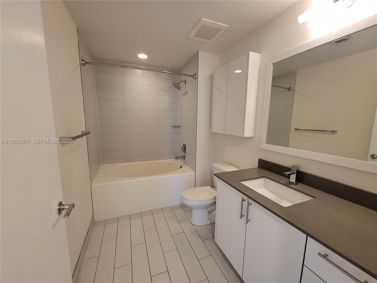 999 Southwest 1st Avenue, Unit 2016 Miami, FL 33130 - Photo 41 of 49 a bathroom with a sink a toilet and shower