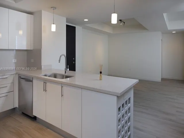 a kitchen with stainless steel appliances a sink a stove a refrigerator and cabinets