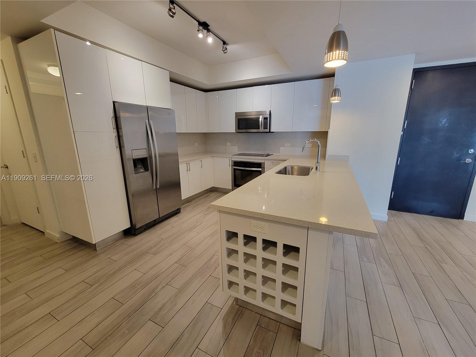 999 Southwest 1st Avenue, Unit 2016 Miami, FL 33130 - Photo 9 of 49 a kitchen with stainless steel appliances a sink a stove a refrigerator and cabinets