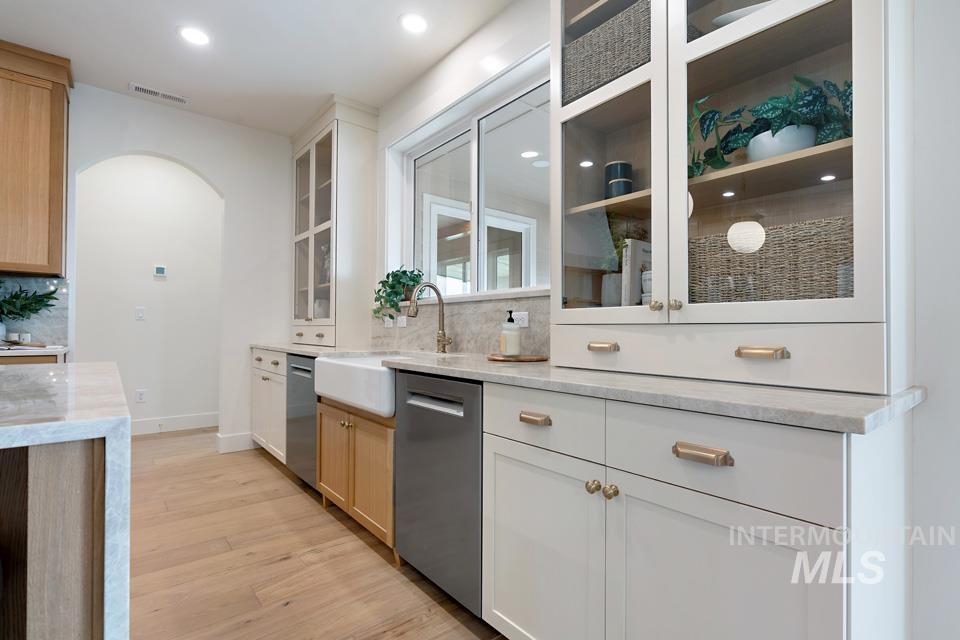 3322 South Volunteer Place Meridian, ID 83642 - Photo 16 of 50 Kitchen featuring light stone countertops, arched walkways, light wood finished floors, stainless steel dishwasher, and recessed lighting