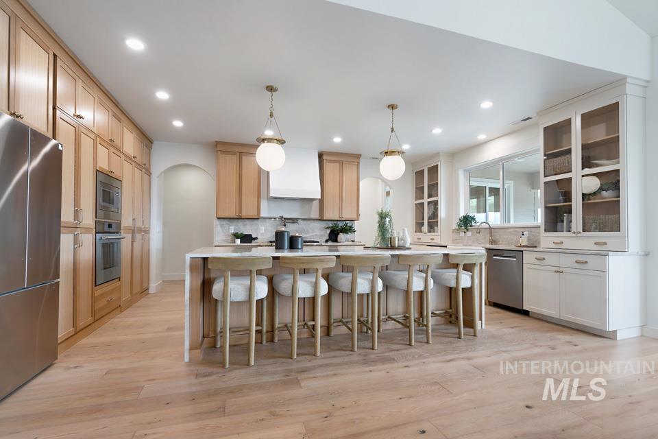 3322 South Volunteer Place Meridian, ID 83642 - Photo 27 of 50 Kitchen featuring hanging light fixtures, a kitchen breakfast bar, a center island, stainless steel appliances, and light wood-style floors